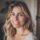 Femme souriante aux cheveux blonds dans la lumière naturelle.